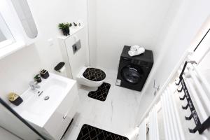 uma casa de banho com um lavatório e uma máquina de lavar roupa em Apartament Modern Ivory Pipera em Voluntari