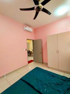 een woonkamer met een plafondventilator en een blauw tapijt bij Yaya Suites Homestay Palmyra Residence Bangi in Kampong Batu Lima Bangi