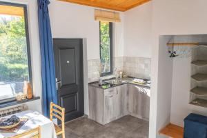 a kitchen with a sink and a table and a window at Art Rooms Garni (Blue Edition) in Garni