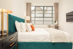 a bedroom with a large bed and a window at Be London - Marylebone Apartments in London