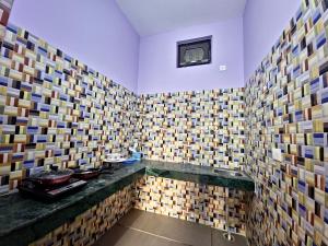 Baño con azulejos de colores en la pared en Karwaan Homestay, en Rishīkesh
