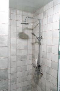 a shower in a bathroom with a tiled wall at Art Rooms Garni (Blue Edition) in Garni