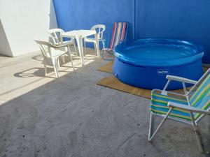 un grupo de sillas, una mesa y una bañera azul en Casa de temporada da Ivalda, en Olímpia
