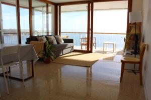 Una sala de estar con un sofá y vista al mar. en Apartamento Torre Alacant, en Alicante