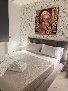 a bed with a painting of a woman with glasses at BRUMARI in Foggia
