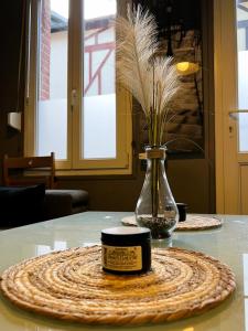 um frasco com uma vela sobre uma mesa com um vaso em Maison de pêcheurs Malvina em Le Tréport