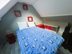 um quarto com uma grande cama azul num sótão em Maison de pêcheurs Malvina em Le Tréport