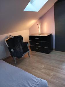 a bedroom with a bed and a dresser and a chair at le calme atlantique in Pornic