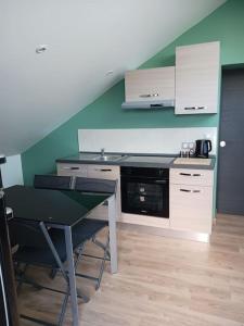 a kitchen with a counter and a table and a stove at le calme atlantique in Pornic