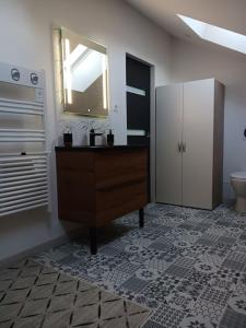 La salle de bains est pourvue d'un lavabo, d'un miroir et de toilettes. dans l'établissement Le moderne pornic, à Pornic