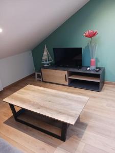 a living room with a tv and a coffee table at le calme atlantique in Pornic