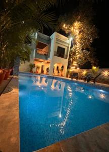 a house with a swimming pool at night at House Of Ubuntu in Rāmtek