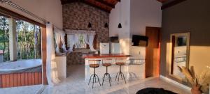 a bathroom with a tub and a bar with stools at Chalés Pura Vida in Itacaré