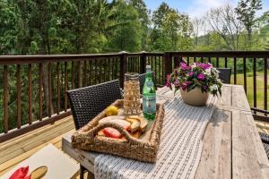 a picnic table with a basket of fruit on a deck at Gorgeous 5 Bdr with Hot Tub - Walk to Holi-Mont! in Ellicottville
