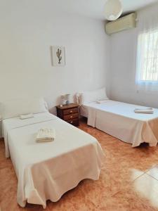 two beds in a room with white walls at Pita 3, San Jose, Nijar in San José