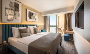 a hotel room with a large bed and a window at Aminess Vival Maestral Hotel in Novigrad Istria