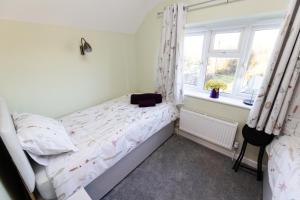 a small bedroom with a bed and a window at One Bridge End in Pevensey