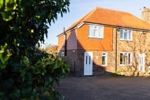 an orange roofed house with a white door at One Bridge End in Pevensey