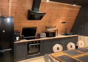 a kitchen with a black refrigerator and a stove at Black Chalet in Vartop