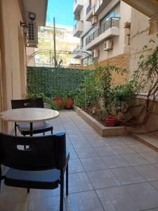 een patio met een tafel en stoelen in een gebouw bij Irida Equanimity and Cozy Apartment in Thessaloniki