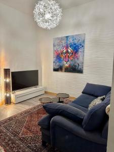 a living room with a blue couch and a painting at Domizil in Schleiden
