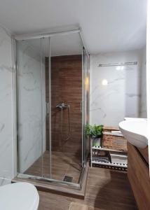 een badkamer met een douche, een toilet en een wastafel bij Irida Equanimity and Cozy Apartment in Thessaloniki