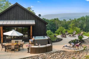 a patio with a hot tub next to a building at Secluded Beauty with Hot Tub & Views in Ellicottville