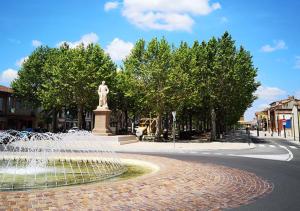 une fontaine avec une statue au milieu d'une rue dans l'établissement RESIDENCE LES JOYAUX, à Muret