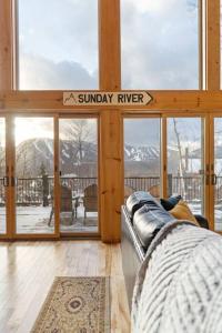 a living room with a couch in front of a window at Chalet*Mountain Views*3-mins Sunday River*Hot Tub in Newry
