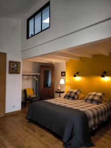 a bedroom with a large bed and a yellow wall at Varzay autour du puits in Varzay