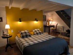 a bedroom with a bed and a yellow wall at Varzay autour du puits in Varzay