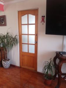 una puerta de madera en una habitación con macetas en Habitación casa familia en La Serena