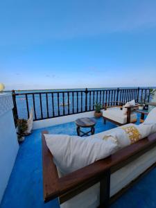 Pwani House - Lamu Seafront في لامو: شرفة مع سرير وإطلالة على المحيط