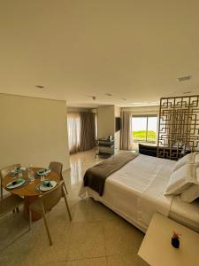 una habitación de hotel con una cama grande y una mesa en Ágape Suítes & Apartamentos en São Sebastião