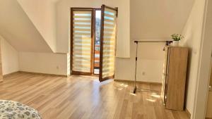 um quarto vazio com piso de madeira e uma porta de correr em Apartament Borowik em Kojszówka