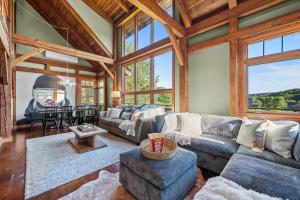 a living room with a couch and a table at Walk to Village! Stunning timber chalet! Hot-Tub, Bonfire & more! in Ellicottville