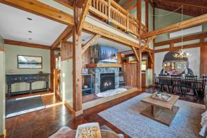 a living room with a fireplace and wooden ceilings at Walk to Village! Stunning timber chalet! Hot-Tub, Bonfire & more! in Ellicottville