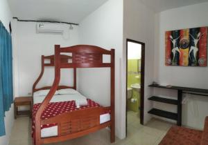 a bedroom with a wooden bunk bed in a room at Hostal Casa Taisha in Montañita