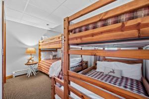 a bedroom with two bunk beds and a lamp at Walk to Village! Stunning timber chalet! Hot-Tub, Bonfire & more! in Ellicottville