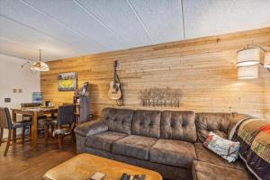 a living room with a couch and a table and a guitar at Pinnacle B14 in Killington