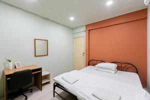 um quarto com uma cama e uma secretária com um computador em Freesia Saladaeng Silom Apartments em Bangkok