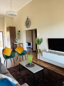 uma sala de estar com um sofá e cadeiras e uma televisão em Pine View Guesthouse Graskop em Graskop