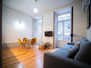 ein Wohnzimmer mit einem blauen Sofa und einem Tisch in der Unterkunft Oporto City View- Trindade luxury in Porto