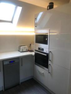 uma cozinha com electrodomésticos brancos e uma janela em Bradford Drive em Mile End