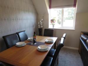 a dining room table with chairs and a bottle of wine at Bradford Drive in Mile End