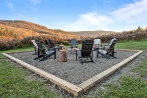 un groupe de chaises assises au sommet de gravier dans l'établissement New & Stunning Chalet! Reno'd, Hot-Tub, Barrel Sauna, Slope Views, Fire Pit, à Ellicottville