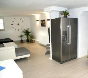 uma sala de estar com um frigorífico de aço inoxidável em Wohnung am HELLER em Nürtingen