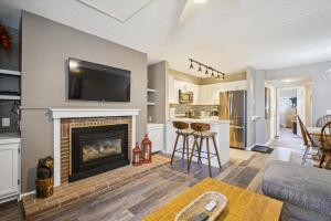 a living room with a fireplace and a tv at Pinnacle B12 in Killington