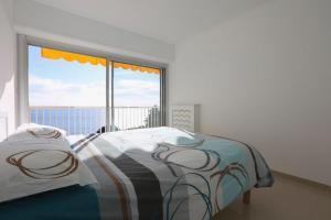 a bedroom with a bed and a large window at BRIDGESTREET MONACO - cap d ail - roquebrune in Saint-Antoine