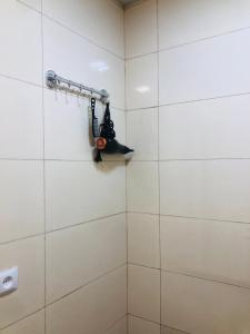 a shower in a bathroom with white tiles at Kutaisi Hotel Bzholebi in Kutaisi